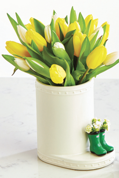 A beautiful arrangement of yellow tulips in a nora fleming porcelain vase.