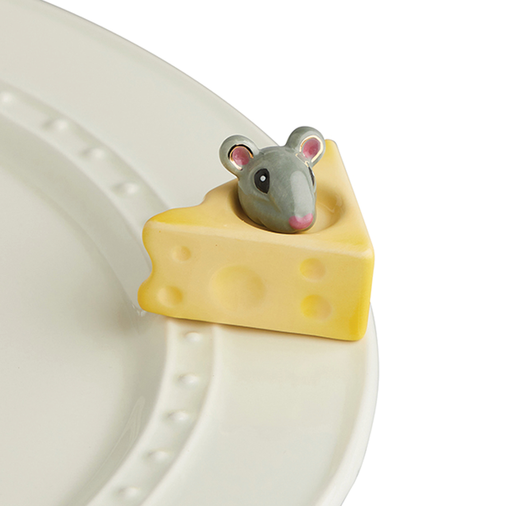 A porcelain wedge of cheese with a mouse peeking out of the top.