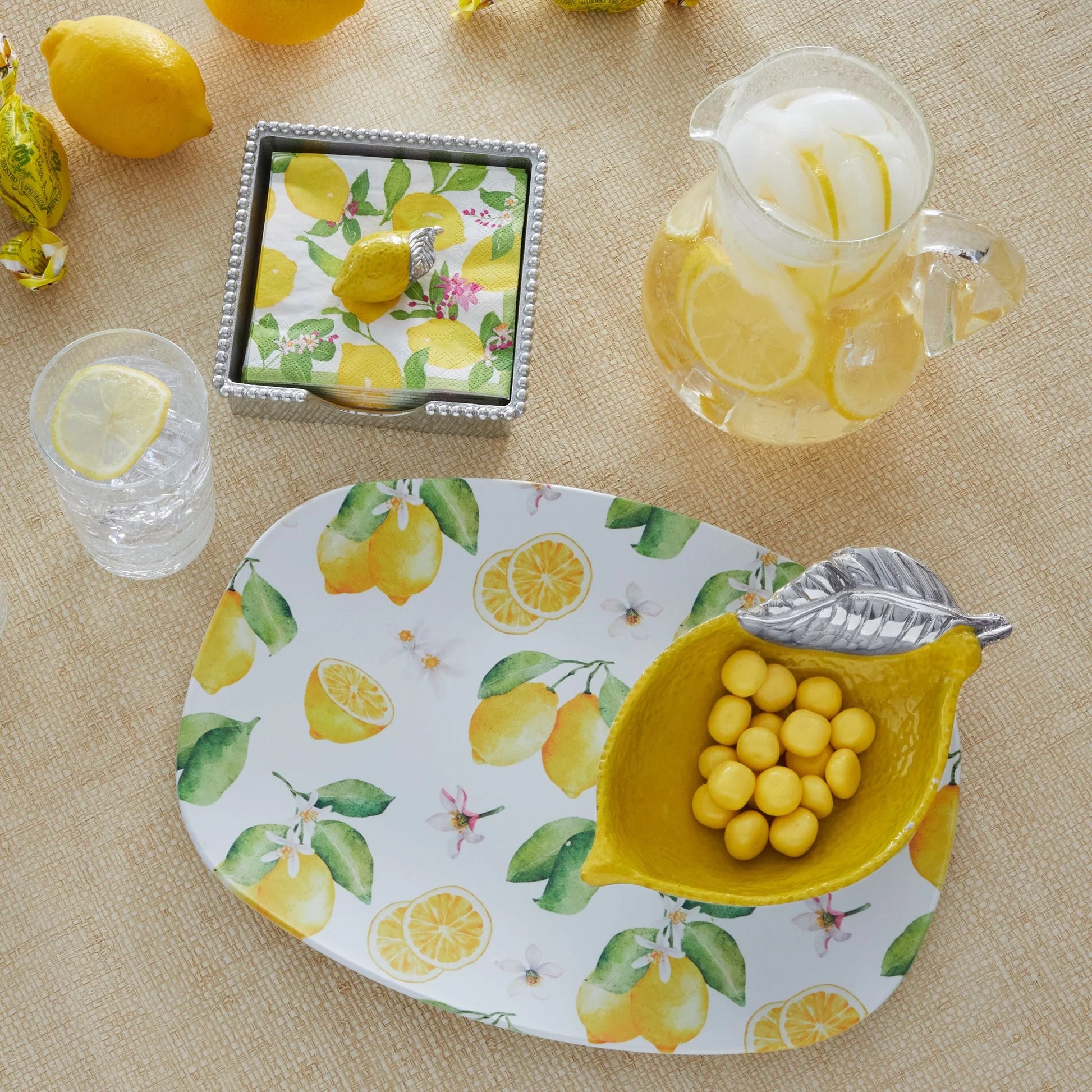 Table setting with lemon-themed tableware including a plate, bowl, and glass on a beige surface.