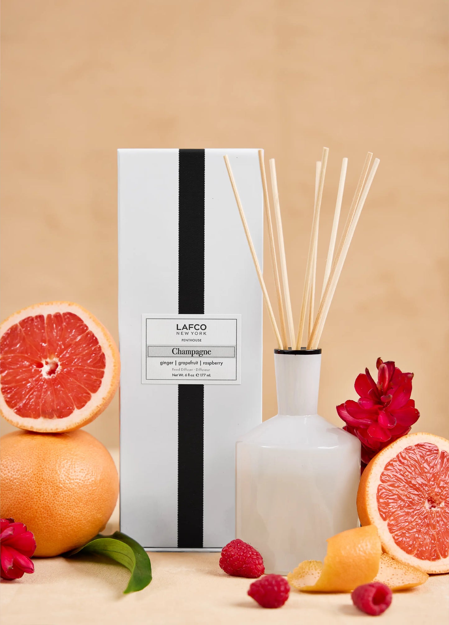 Lafco diffuser with grapefruit, raspberry, and orange on a beige background