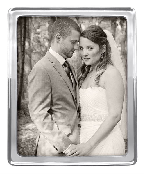 A 8" by 10" silver photo frame with a stock photo of a couple on their wedding day.