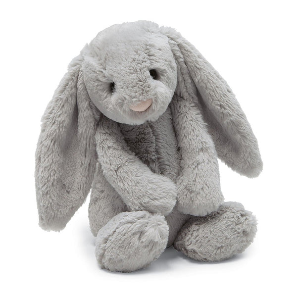 A plush grey bunny sitting on a white background