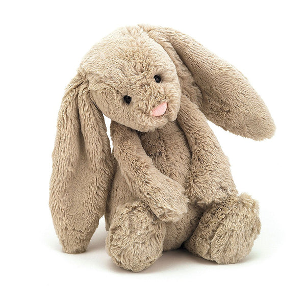 A beige plush bunny with his head tilted slightly on a white background.