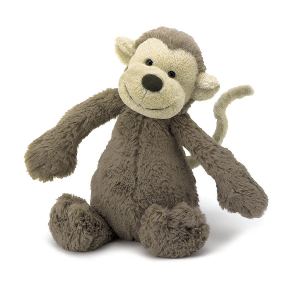 A deep brown plush monkey sitting happily on a white background.