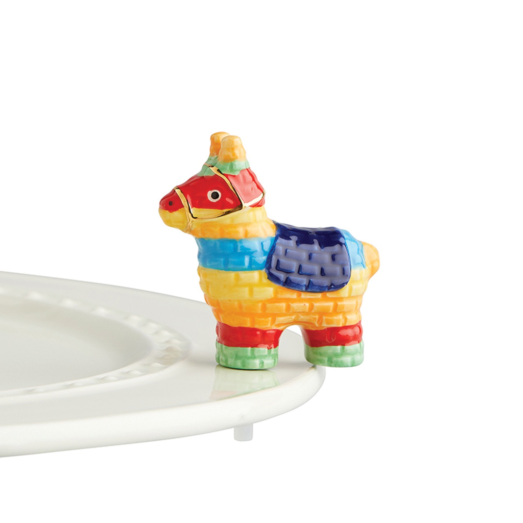 A festive porcelain miniature model of a pinata sitting on top of a plate.